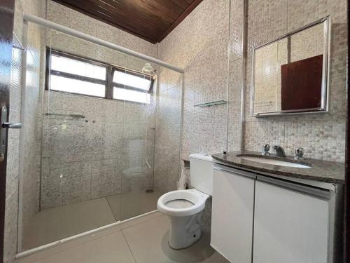 a bathroom with a toilet and a shower and a sink at A 4 minutos a pé da praia. in Itanhaém