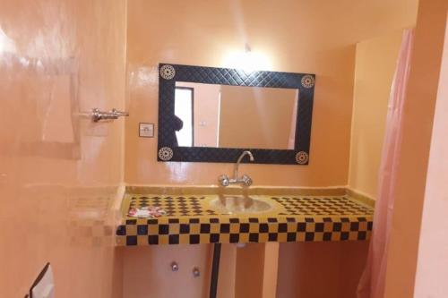 a bathroom with a sink and a mirror at Auberge Sahara Garden in Lac Yasmins