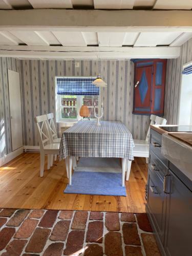eine Küche mit einem Tisch, einem Tisch und Stühlen in der Unterkunft Stavsmyra in Eskilstuna
