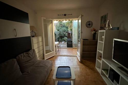 - un salon avec un canapé et une porte donnant sur une terrasse dans l'établissement Studio coin nuit fermé 4 personnes - Les Mas de La Plage, à Sanary-sur-Mer