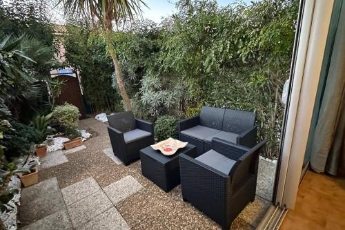 eine Terrasse mit zwei Stühlen und einem Tisch in der Unterkunft Studio coin nuit fermé 4 personnes - Les Mas de La Plage in Sanary-sur-Mer