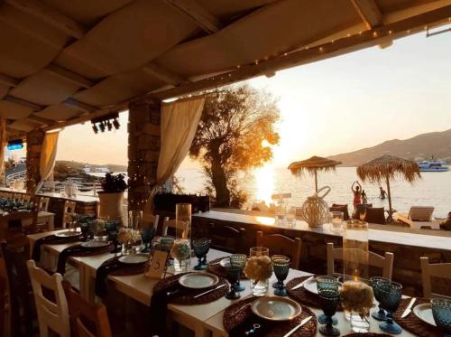 a restaurant with tables and chairs with a view of the water at Boutique ''Di Mare'' Hotel & Suites in Posidhonía