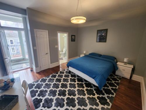1 dormitorio con cama azul y alfombra blanca y negra en Downtown Toronto Townhouse, en Toronto