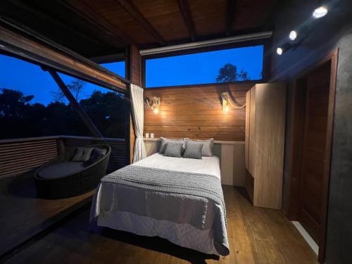 1 dormitorio con cama y ventana grande en Paradouro Monã, en Torres