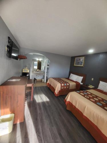 a hotel room with two beds and a desk at Budget Inn Buffalo in Buffalo