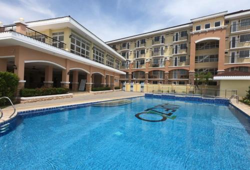 a large swimming pool in front of a building at Jay's Condo @ Arrezo in Davao City