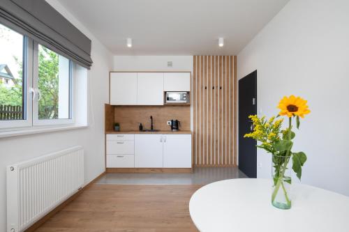 a kitchen with a table and a vase with a sunflower at Gorczański Zakątek in Konina