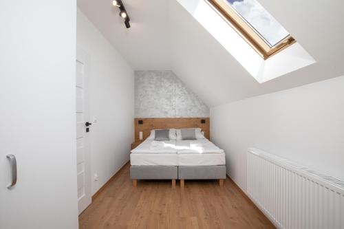 a bedroom with a bed and a skylight at Gorczański Zakątek in Konina
