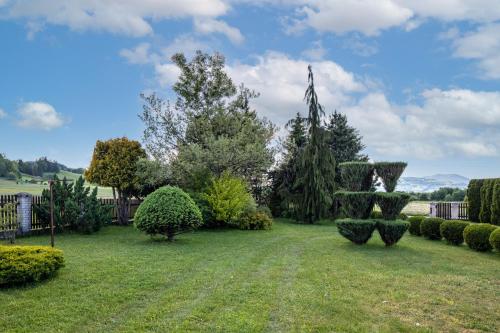 a garden with bushes and trees on a field at Gorczański Zakątek in Konina