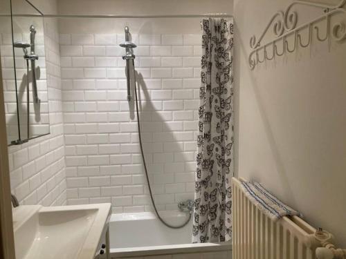 La salle de bains blanche est pourvue d'une douche et d'un lavabo. dans l'établissement Charming Sunny 100m2 Entire Apartment with 2 bedrooms, à Brasschaat