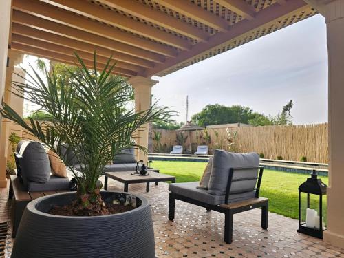 un patio con 2 sillas y una maceta en Villa Naya et sa Piscine chauffée sans vis-à-vis, en Agadir