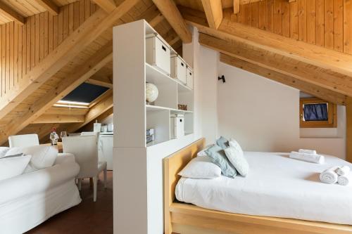 a bedroom with a white bed and a white couch at Mortara Navigli Apartments in Milan