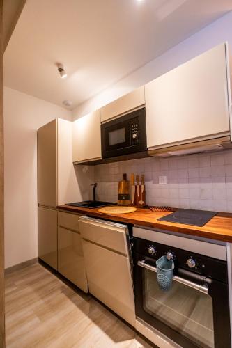 une cuisine avec des appareils en acier inoxydable et un micro-ondes dans l'établissement La Suite, à Marseille