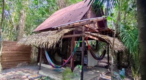 a small hut with a thatched roof and hose at Casa Embira - 300 metros da Praia do Lago Verde in Alter do Chao