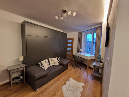 a living room with a couch and a desk at Cozy Apt Near Prague Castle in Prague