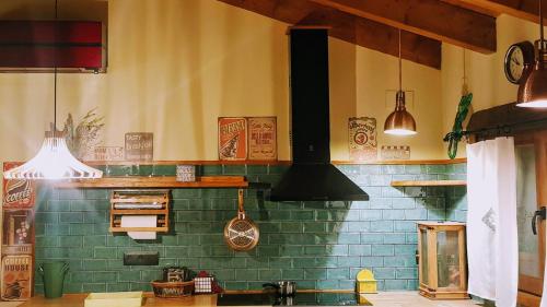 una cocina con una pared de azulejos verdes y un fregadero en Casa Ton del Mingo, en Sant Cerni