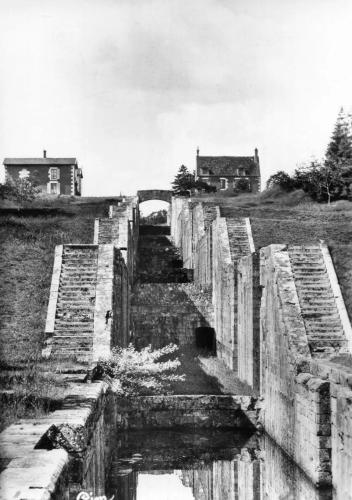 a black and white photo of an old stone bridge at l'aube des 7 ecluses in Rogny