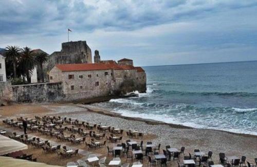 a beach with a bunch of chairs and the ocean at OLD TOWN Budva apart 3 with balcony in Budva