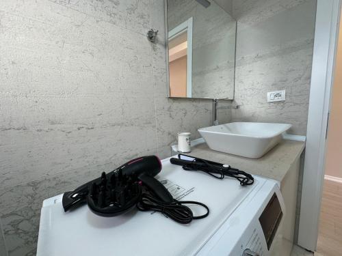 een badkamer met een zwarte haardroger op een aanrecht bij Skyline Panoramic Apartment in Tirana