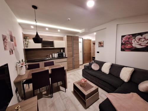 a living room with a couch and a table and a kitchen at Apartmani L6 & P90 Milmari Kopaonik in Kopaonik
