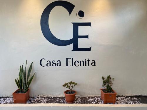a sign for a casa elfina on a wall with plants at Casa Elenita in San Juan La Laguna