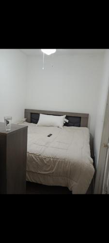 um quarto com uma cama branca e uma mesa de cabeceira em Casa Puente del Zorro em Ciudad Juárez