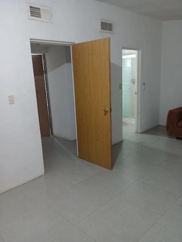 um quarto vazio com uma porta de madeira e piso branco em Casa Puente del Zorro em Ciudad Juárez