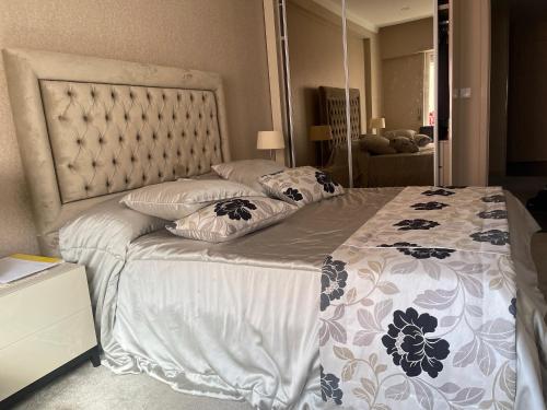 een slaapkamer met een groot bed en een grote spiegel bij Casa do K in Corroios