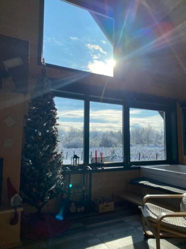 a christmas tree in a room with a window at River House Moon in Gospić