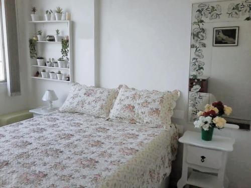 Un dormitorio con una cama con flores. en Sun Apartamento Copacabana, en Río de Janeiro