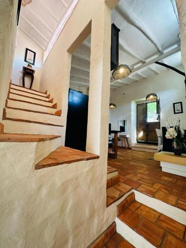 una sala de estar con escaleras y una mesa en una habitación en Hospedaje La Casita de Maria en Barichara