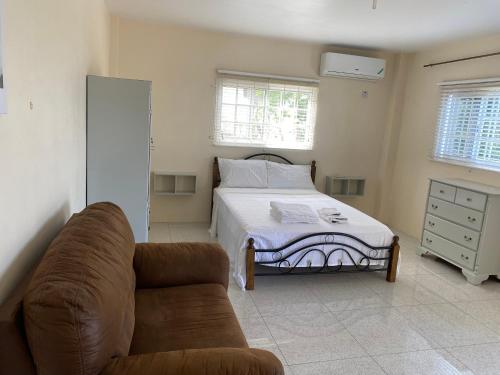 salon z łóżkiem i kanapą w obiekcie Studio flat w mieście Montego Bay
