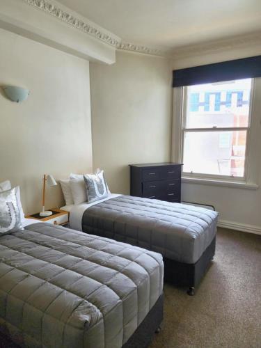 a hotel room with two beds and a window at U Suites on Manners in Wellington