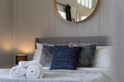 a bedroom with a bed with a mirror and towels at Loft Ninety Three - Stylish & Central in Orange