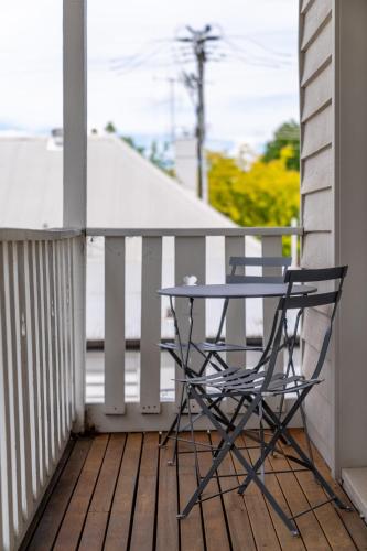 a table and a chair sitting on a porch at Loft Ninety Three - Stylish & Central in Orange