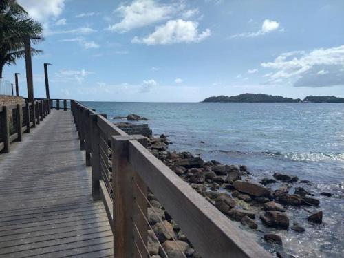 a wooden boardwalk leading to the ocean on a beach at Mini casa Contêiner em Bombas in Bombinhas