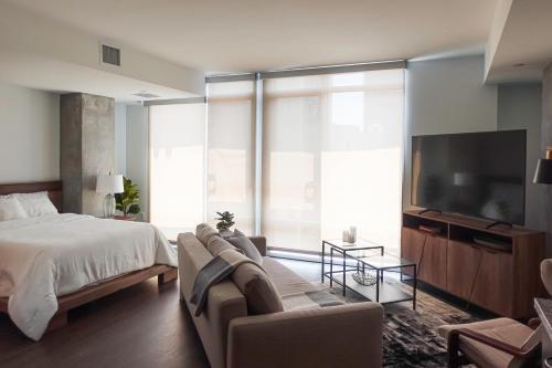 um quarto com uma cama, uma televisão e um sofá em Luxurious Hollywood Dream em Los Angeles