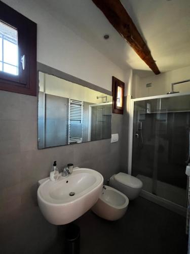 Santa Croce Apartment في البندقية: حمام مع حوض ومرحاض ومرآة