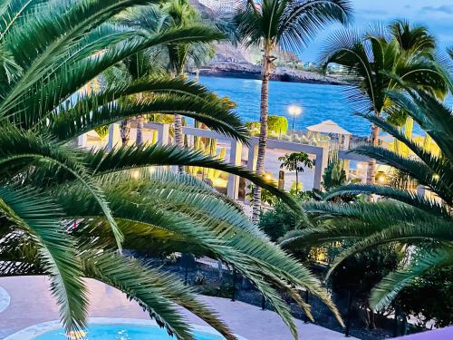 a view of a resort with palm trees and the ocean at PLAYA DEL CURA - Spacious Beachside Apartment in Playa del Cura