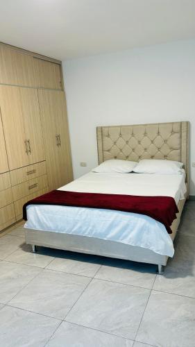 Apto con parqueadero Escalini Mansión Puerta del sol Pitalito في بيتاليتو: غرفة نوم بسرير كبير مع بطانية حمراء