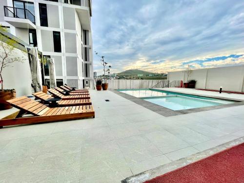 een patio met stoelen en een zwembad in een gebouw bij Cozy condo lake view 15th floor in León