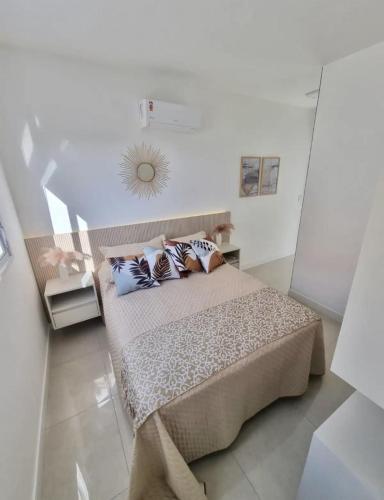 a bedroom with a large bed with pillows on it at Apto decorado e bem localizado in Capão da Canoa