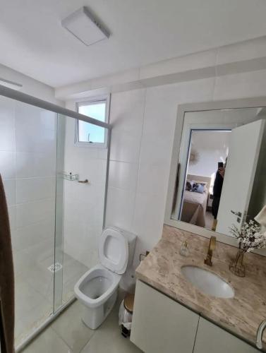 uma casa de banho com um WC, um lavatório e um chuveiro em Apto decorado e bem localizado em Capão da Canoa