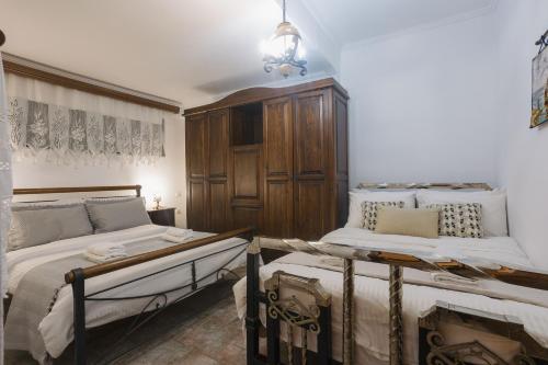 a bedroom with two beds and a chandelier at Billiard Home in Trikala in Tríkala