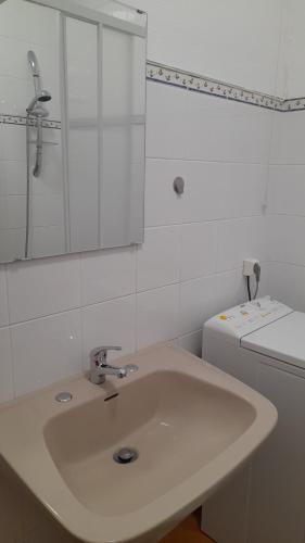 a white bathroom with a sink and a toilet at Na Rota - Casa de Praia in Zambujeira do Mar