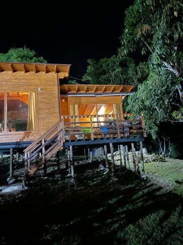 a large wooden cabin with a table and benches at Las Nubes Cabaña in La Mesa