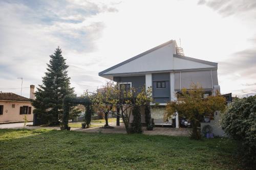 a white house with a tree in the yard at Billiard Home in Trikala in Tríkala