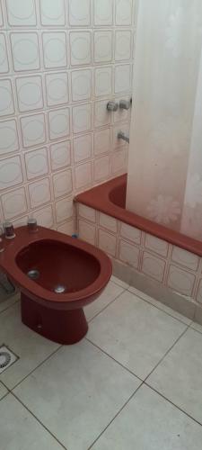 y baño con lavabo rojo y bañera. en departamento centrico en Mar del Plata