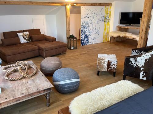 a living room with a couch and a table at Glückliche Kuh-Villa - Achtsamer Rückzugsort mit Traumgarten, Schwimmteich & Raum zum Sein bis 18 Personen - Allgäu in Kempten