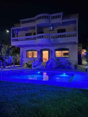 a large white house with a swimming pool at night at Paradise house in Marrakech
